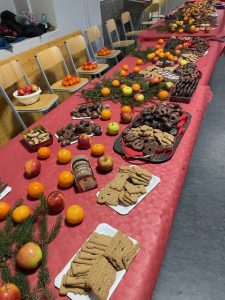 Buffet mit Weihnachts-Süßigkeiten, Äpfeln und Orangen zur Verteilung an die Schüler:innen